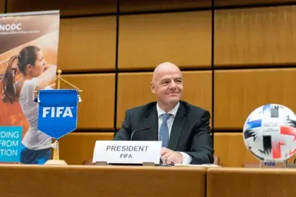Gianni Infantino sentado ante un micrófono junto a un balón