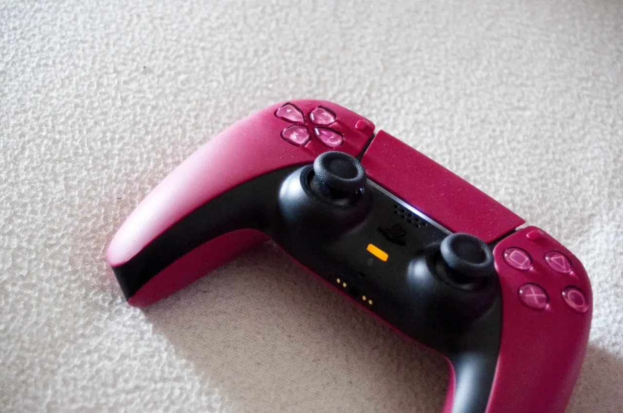 Control DualSense magenta de PS5 sobre una superficie clara