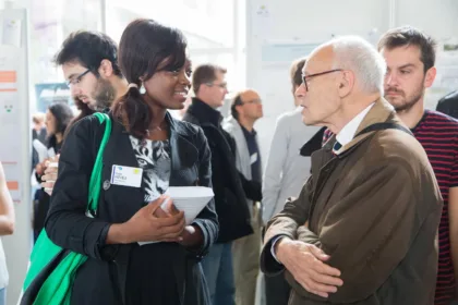 Henri Kagan conversa con asistentes a un encuentro de química orgánica