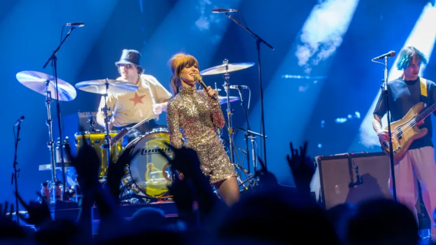 Hayley Williams singing with Paramore on a stage in London in 2023