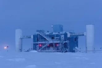 Laboratorio IceCube en el Polo Sur durante el crepúsculo, con la Luna cerca del horizonte
