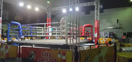 Ring de boxeo iluminado en un recinto deportivo
