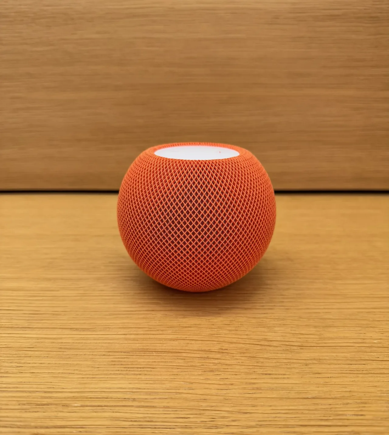 HomePod mini sobre una superficie de madera, fotografía de archivo