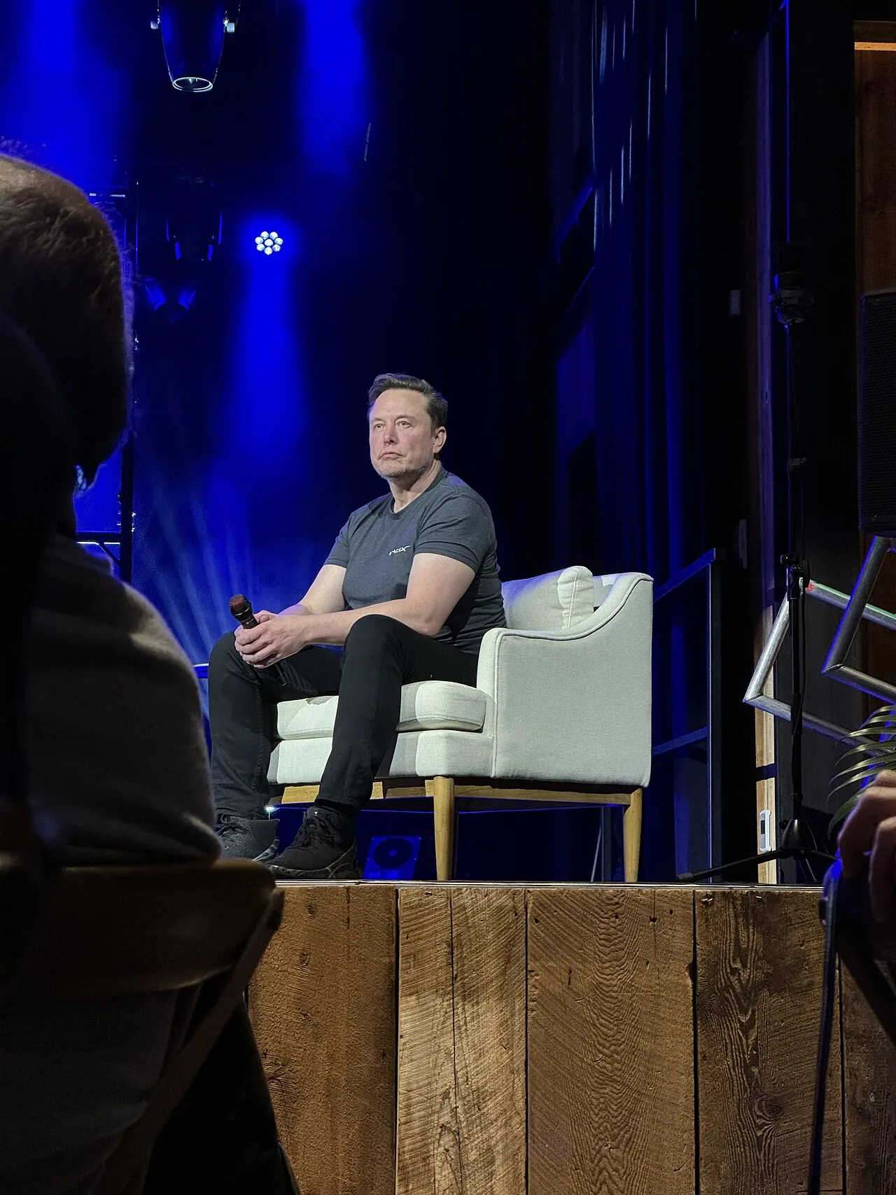 Foto de archivo de Elon Musk sentado en un sillón y sosteniendo un micrófono durante una conferencia, el 28 de marzo de 2024.
