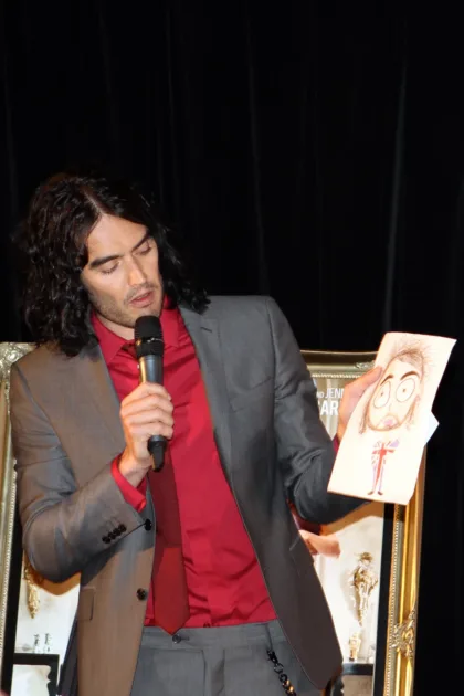 File photo of Russell Brand holding a microphone and an illustration, on 15 of April 2011.