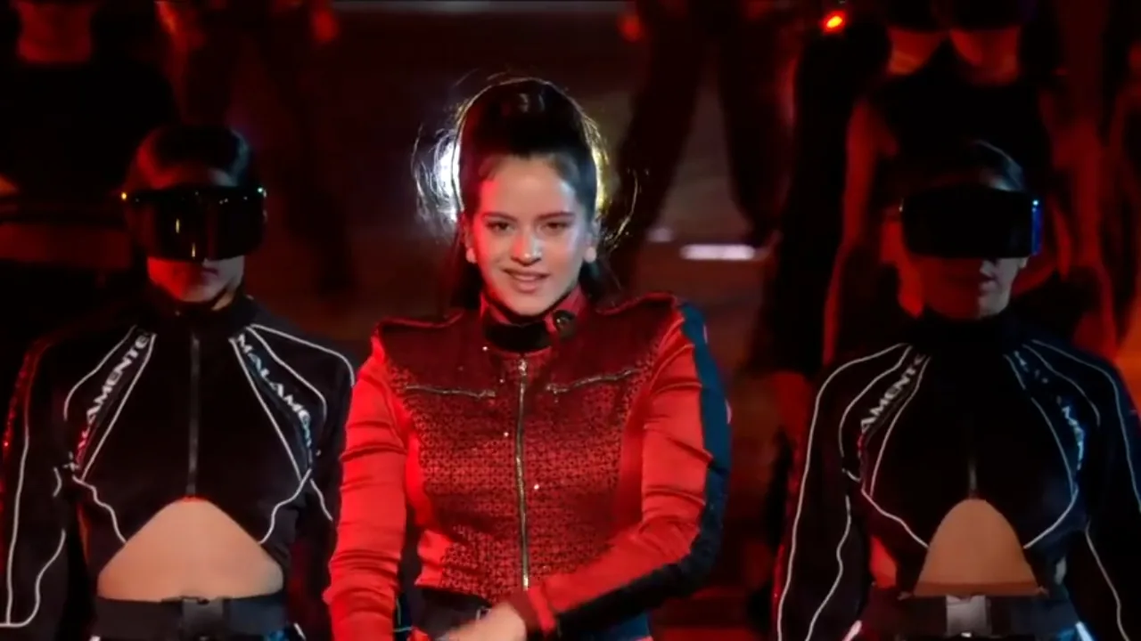 File photo from November 5, 2018: Rosalía, dressed in red, appears on a red-lit stage with two dancers.