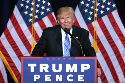 Foto de archivo del 31 de agosto de 2016: Donald Trump habla ante un micrófono, detrás de un atril con el texto «Trump Pence», con banderas de Estados Unidos al fondo.