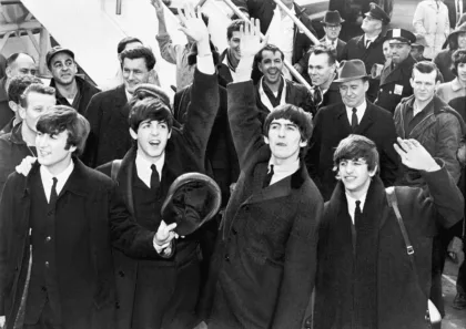 Archive photo from February 7, 1964: The Beatles wave to the crowd after arriving at JFK Airport.